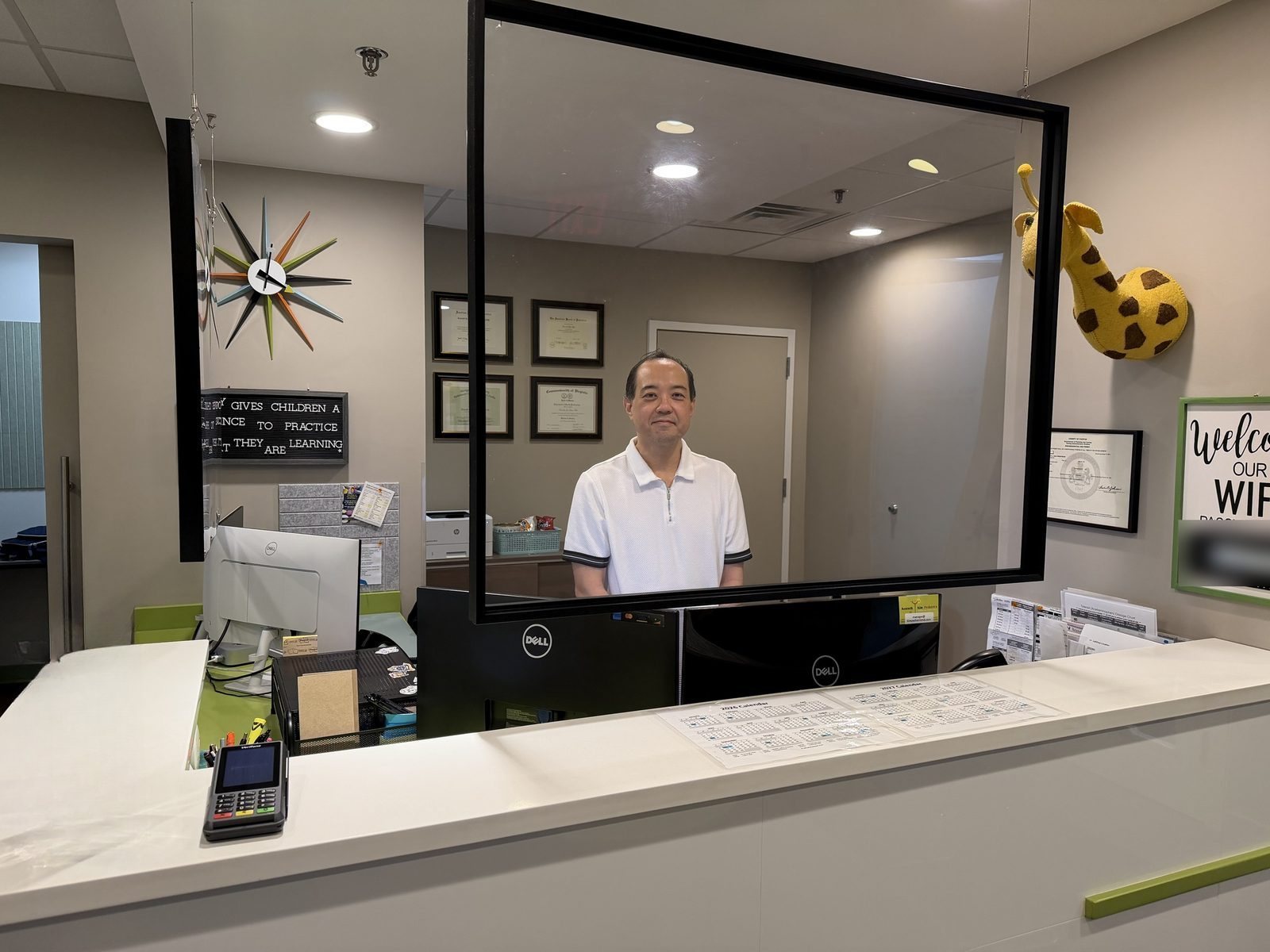 Front desk and check-in counter, with a cheerful giraffe on the wall